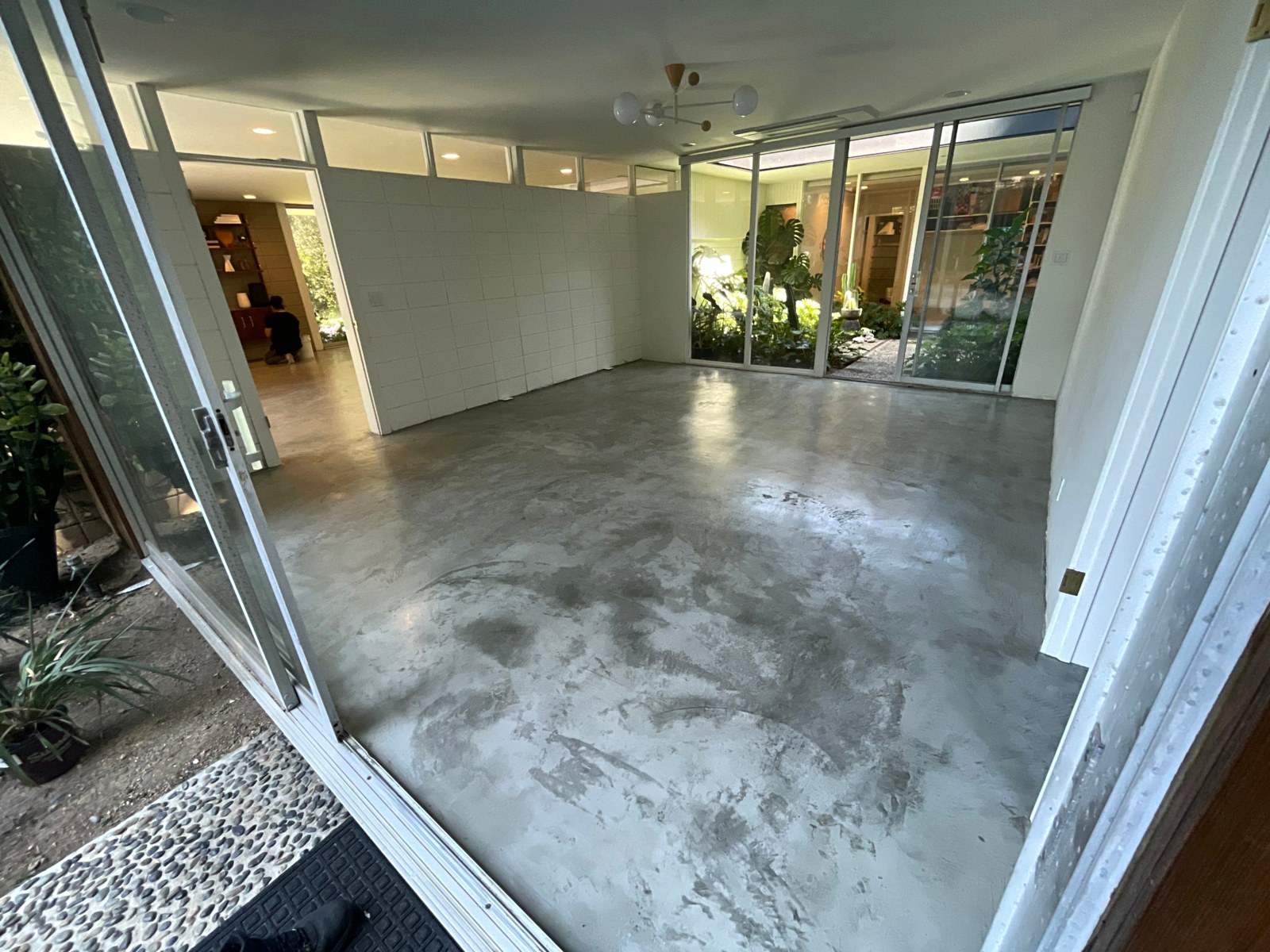 Microcement atrium floor opening to a courtyard