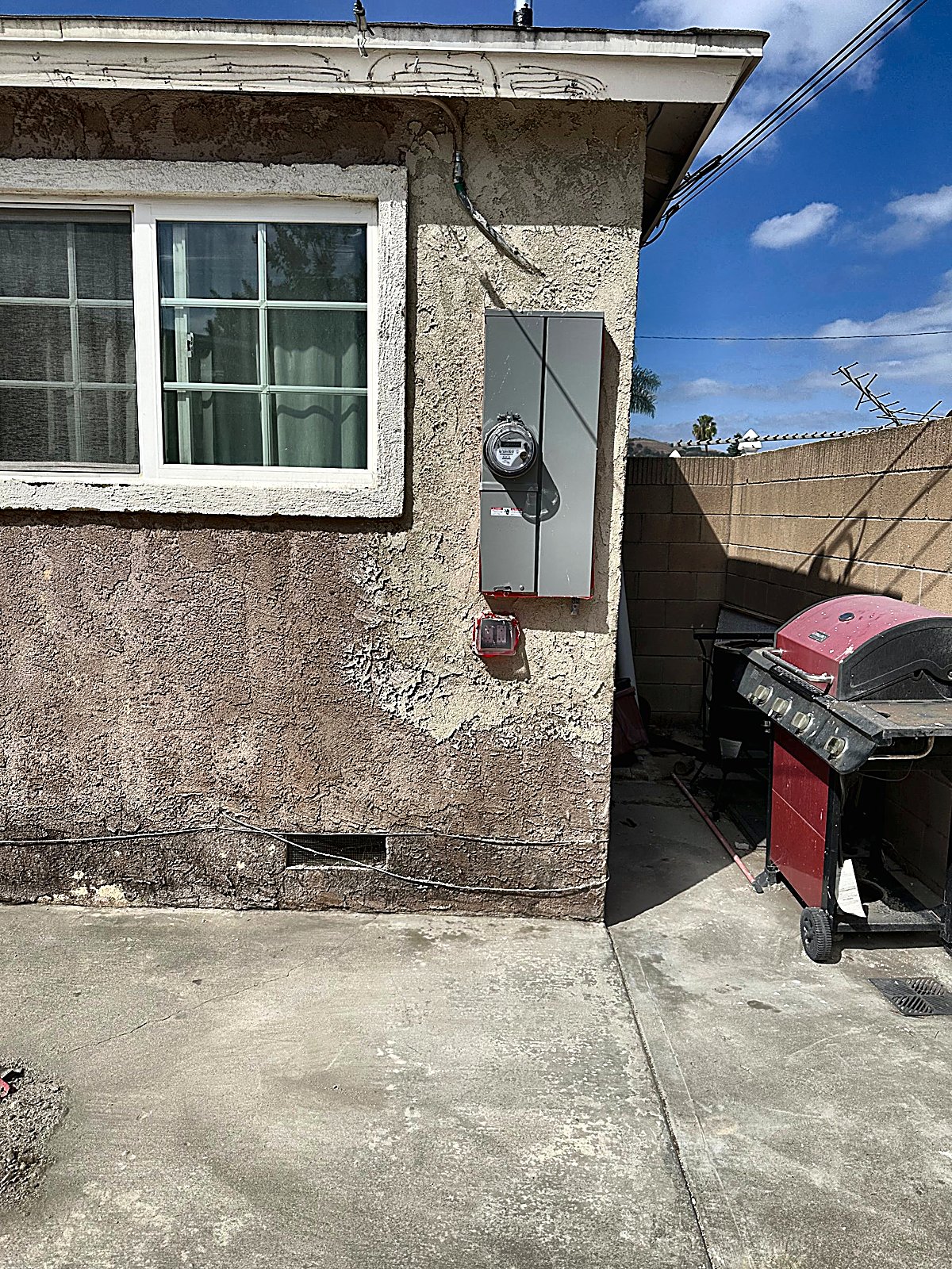 Finished stucco around the meter on a pink house