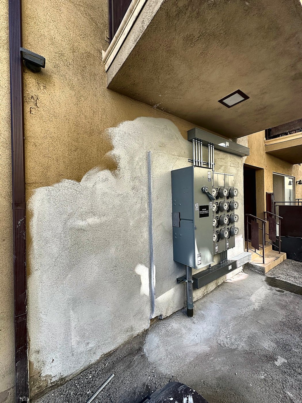 Patched stucco around the meter bank