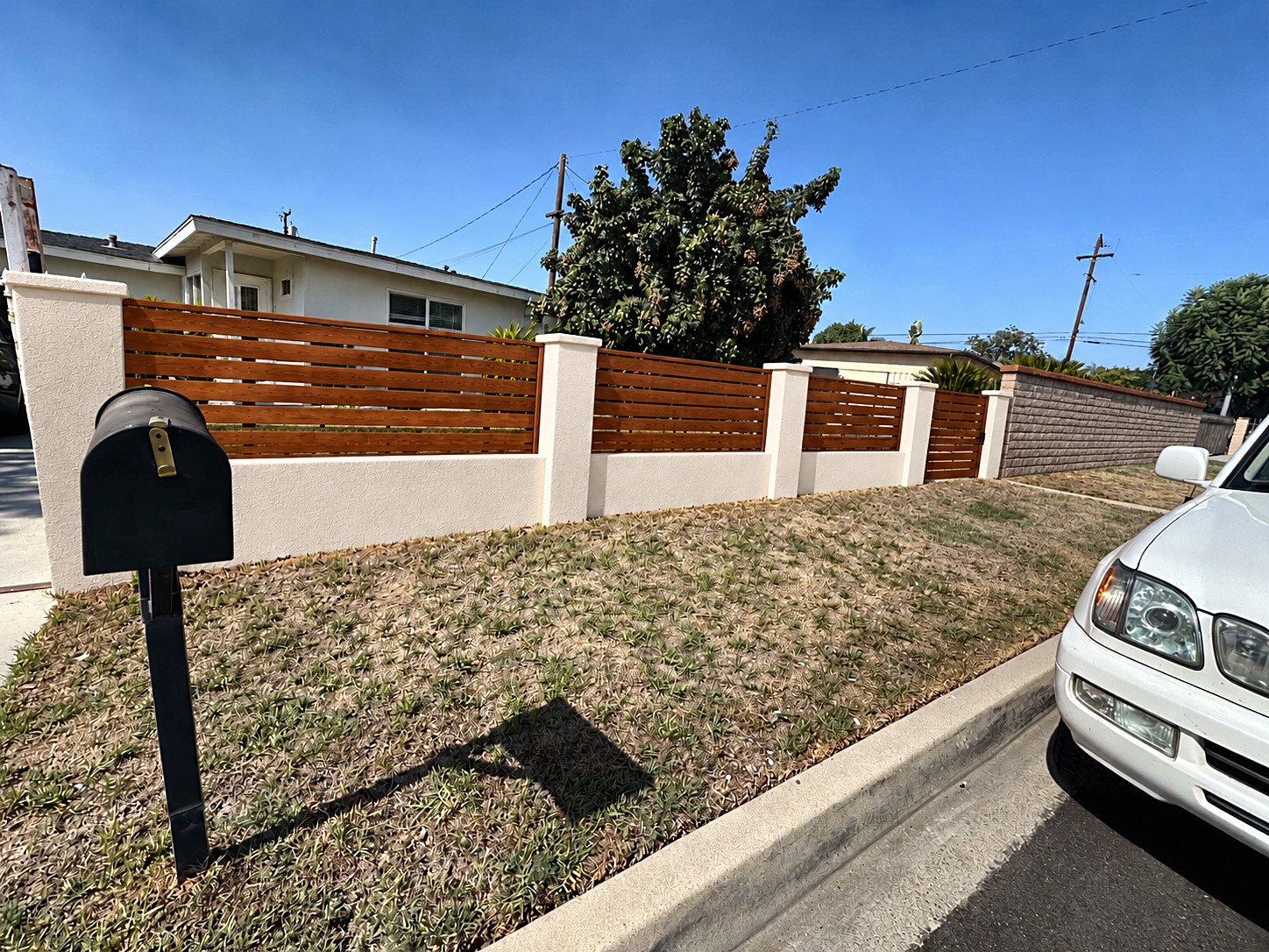 Stucco wall with wood slat fence after the work