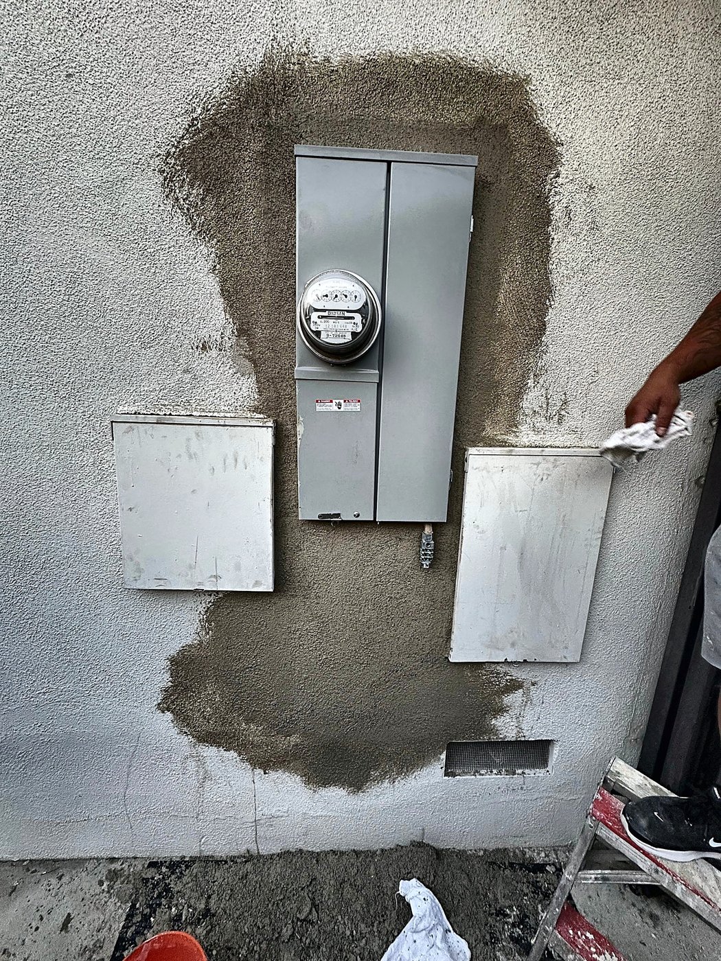 Stucco patched around the electric meter